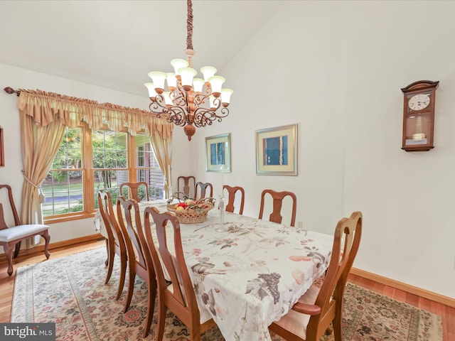 dining area with a notable chandelier, high vaulted ceiling, and light wood-type flooring