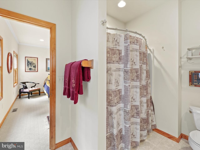 bathroom featuring tile flooring and toilet