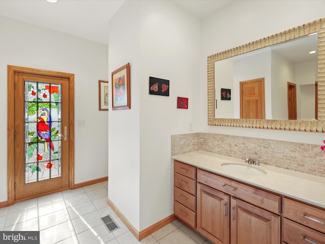 bathroom with tasteful backsplash, tile floors, and vanity