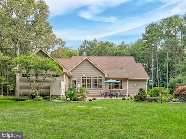 rear view of house featuring a lawn and a patio