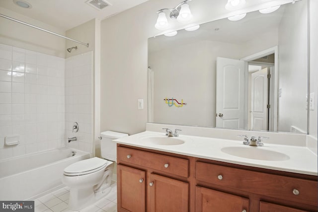 full bathroom featuring dual vanity, tile flooring, toilet, and tiled shower / bath