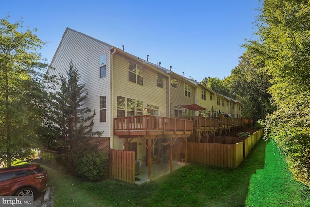 rear view of property with a deck and a lawn