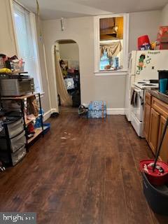 interior space with stove, dark wood-type flooring, and white refrigerator