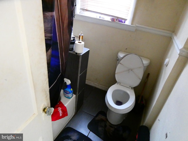 bathroom featuring tile flooring and toilet