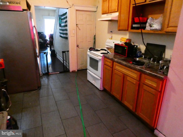 kitchen with sink, dark tile flooring, refrigerator, and white range with gas stovetop