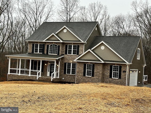 view of front of house with brick siding, covered porch, and a garage