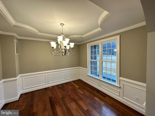 unfurnished dining area with visible vents, a tray ceiling, dark wood-type flooring, and an inviting chandelier