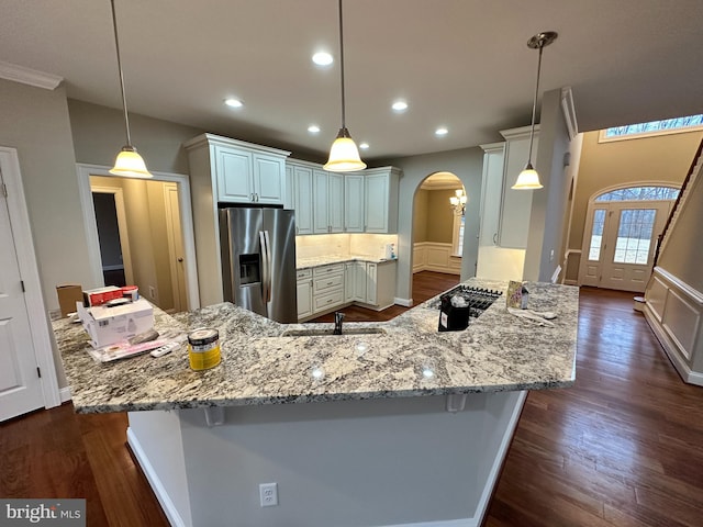 kitchen featuring arched walkways, dark wood-style floors, recessed lighting, and stainless steel appliances