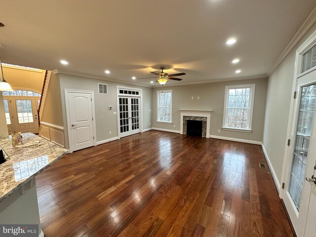 unfurnished living room with visible vents, baseboards, dark wood-style floors, and a fireplace