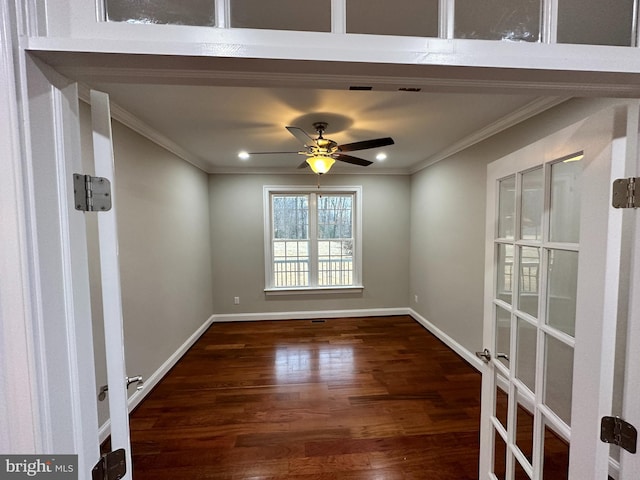 unfurnished room with wood finished floors, a ceiling fan, baseboards, and ornamental molding