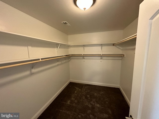 spacious closet with dark colored carpet and visible vents