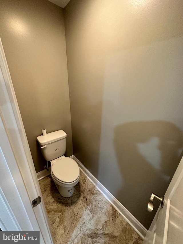 bathroom featuring toilet and baseboards