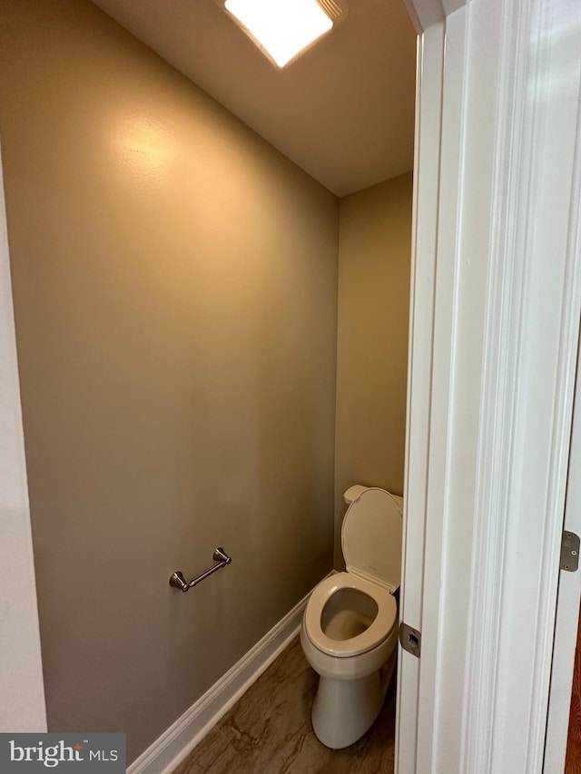 bathroom with baseboards and toilet