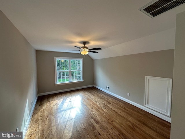 additional living space with visible vents, a ceiling fan, dark wood-style floors, baseboards, and vaulted ceiling