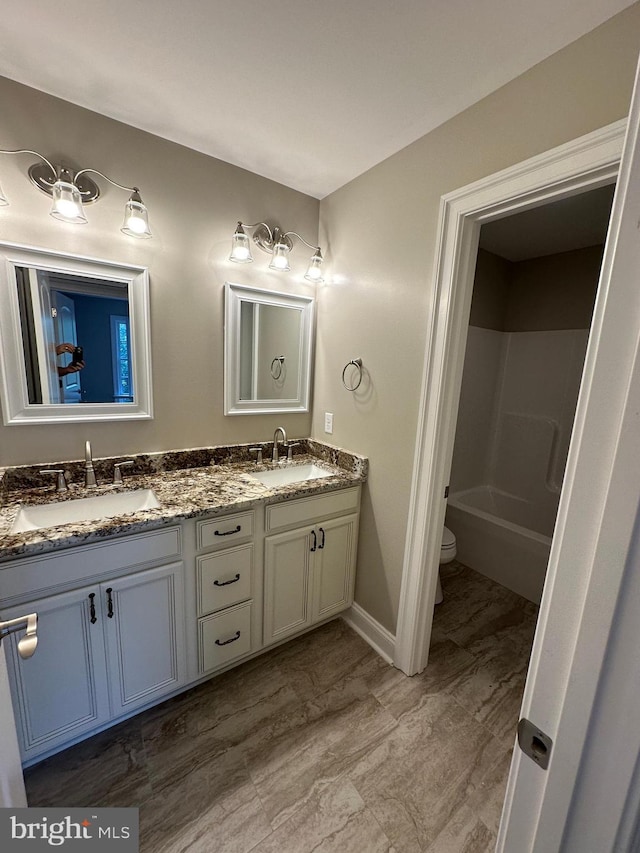 full bath with double vanity, toilet, a shower, and a sink