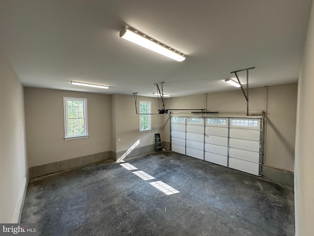 garage featuring a garage door opener and baseboards