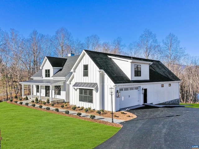 modern farmhouse style home with a porch, a front yard, and a garage