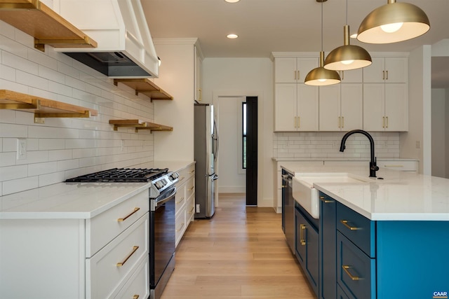 kitchen featuring backsplash, blue cabinets, decorative light fixtures, and appliances with stainless steel finishes