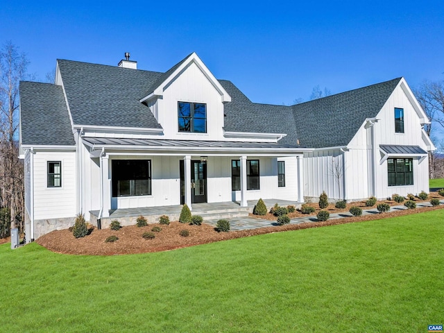 modern farmhouse style home with a front lawn and covered porch