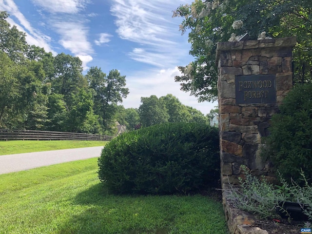 community / neighborhood sign featuring a yard