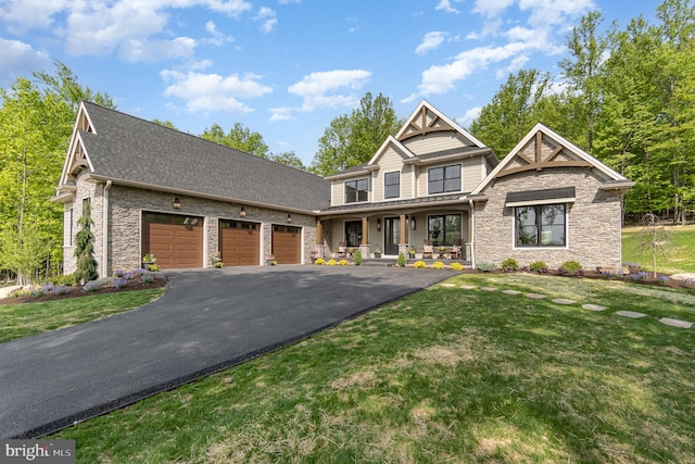 craftsman inspired home with a front yard, a porch, and a garage