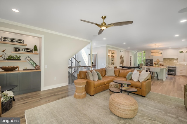 living room featuring light hardwood / wood-style flooring, ceiling fan, and ornamental molding