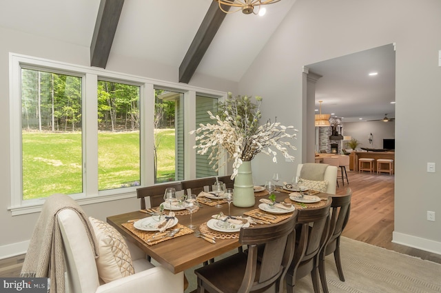 sunroom / solarium featuring vaulted ceiling with beams and ceiling fan with notable chandelier