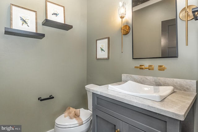 bathroom with toilet and vanity with extensive cabinet space