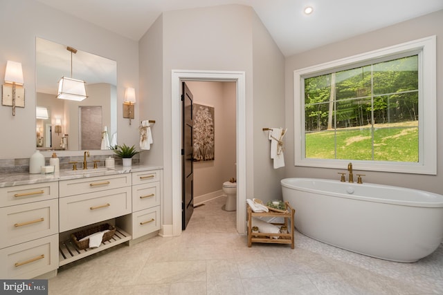 bathroom with vanity, lofted ceiling, tile floors, and toilet