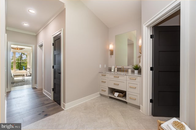 bathroom with ornamental molding, vanity, and hardwood / wood-style flooring