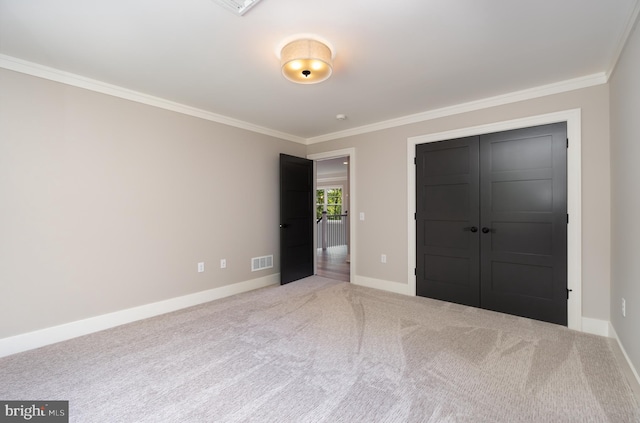 unfurnished bedroom with a closet, light carpet, and ornamental molding