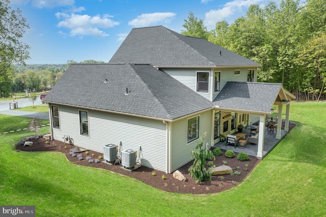 rear view of property with central AC unit, a yard, and a patio area