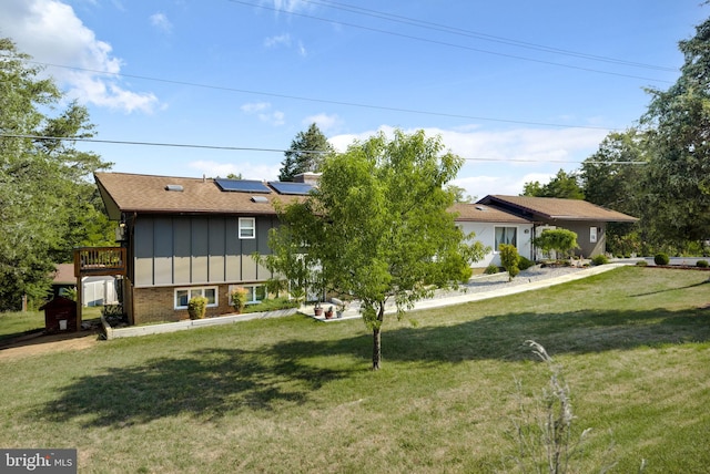 view of front of home featuring a front yard and solar panels