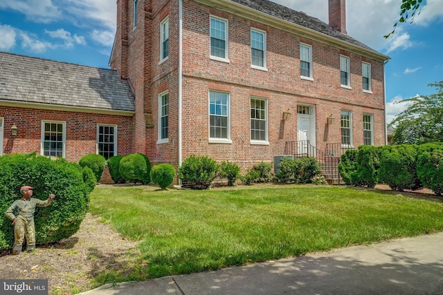 colonial home with a front lawn