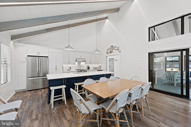 dining room featuring beam ceiling, dark hardwood / wood-style floors, and high vaulted ceiling