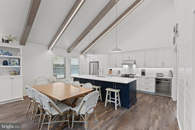 dining room featuring wine cooler, high vaulted ceiling, wood walls, dark hardwood / wood-style floors, and sink