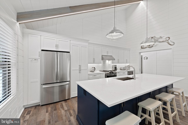 kitchen with white cabinets, pendant lighting, sink, stainless steel appliances, and dark hardwood / wood-style floors