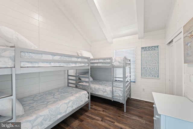 bedroom featuring beam ceiling, wooden walls, high vaulted ceiling, a closet, and dark hardwood / wood-style flooring