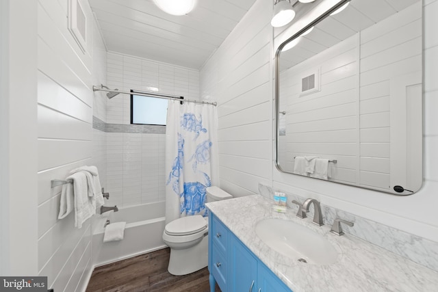 full bathroom featuring vanity, wood walls, shower / bath combo, wood-type flooring, and toilet