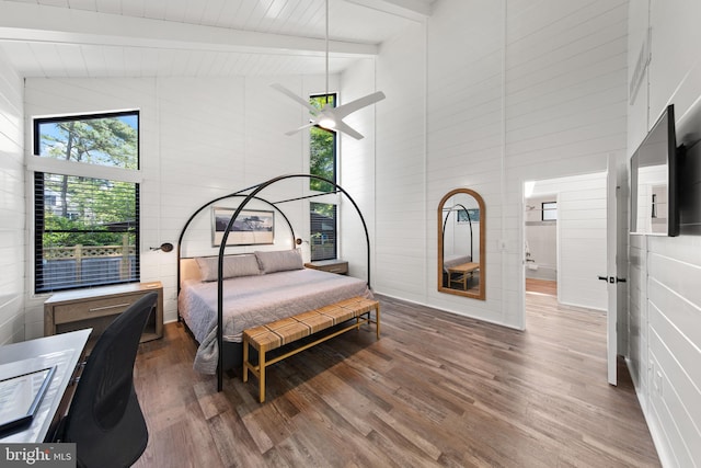 bedroom with hardwood / wood-style flooring, beam ceiling, and high vaulted ceiling