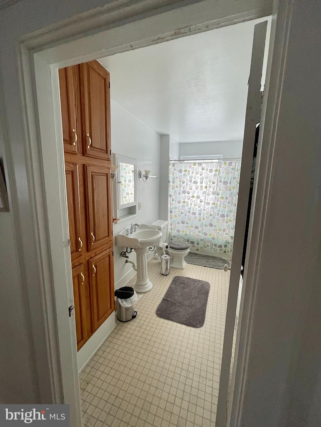 bathroom featuring a bidet, toilet, tile floors, and sink