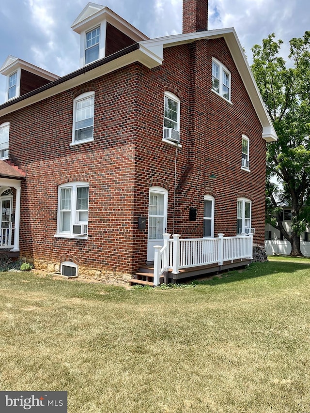 back of property with a deck, central AC, and a yard