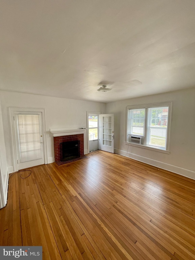 unfurnished living room with a fireplace, light wood-type flooring, and a healthy amount of sunlight