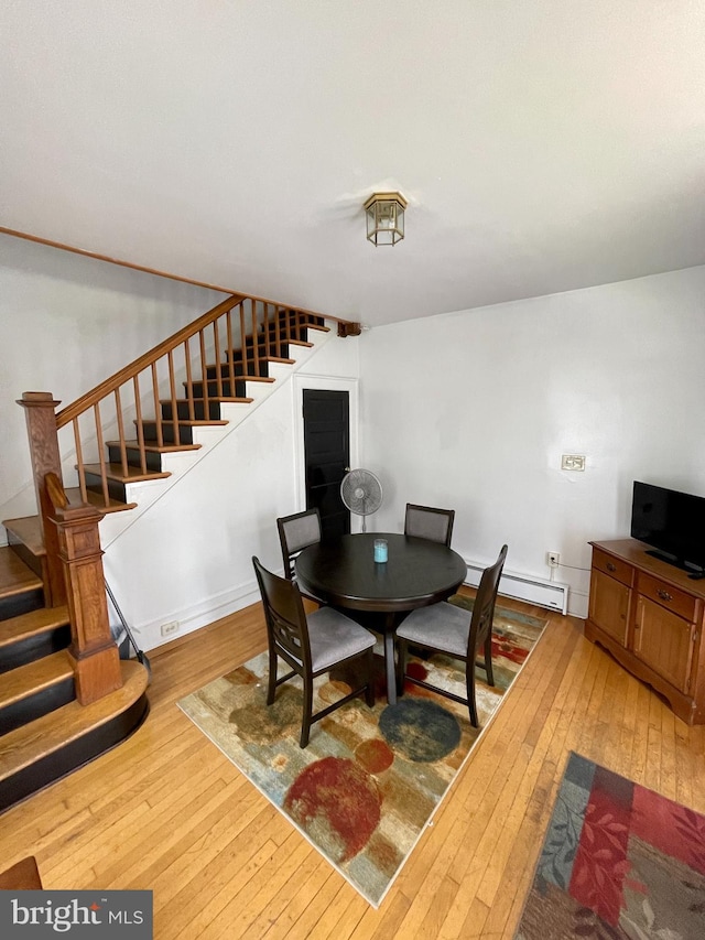 dining area with baseboard heating and light hardwood / wood-style floors