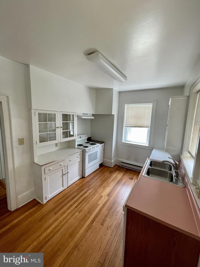 kitchen with light wood-type flooring, a baseboard radiator, white electric range, sink, and white cabinetry