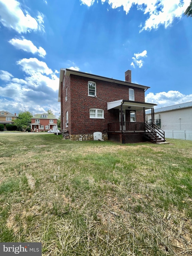 rear view of property featuring a yard