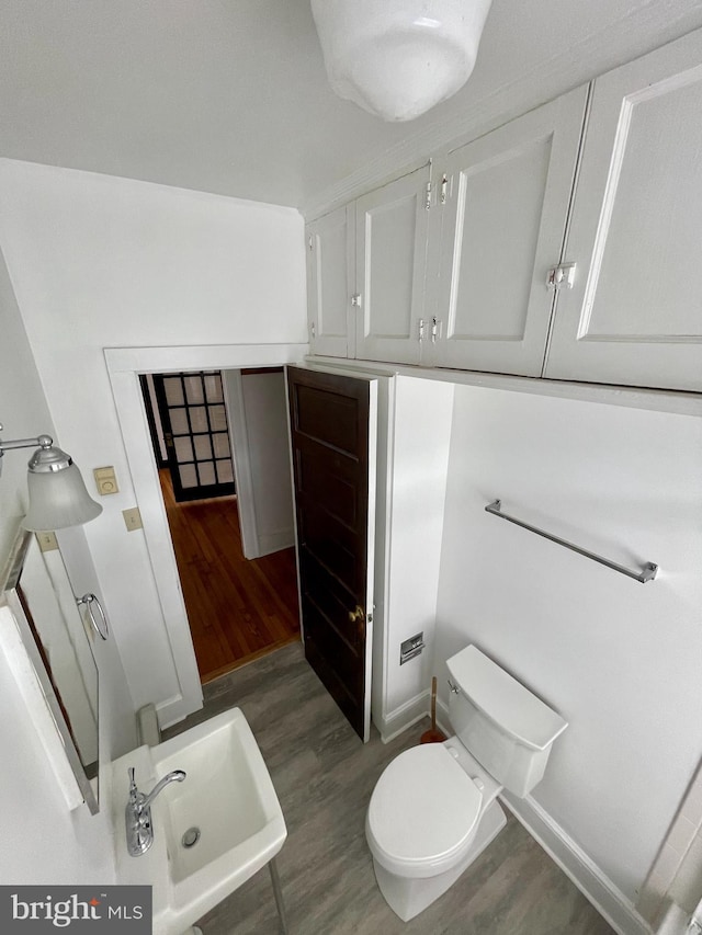 bathroom featuring toilet, sink, and hardwood / wood-style flooring