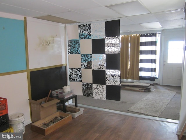 interior space featuring a paneled ceiling and wood-type flooring