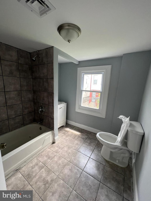 bathroom featuring toilet, tiled shower / bath, and tile flooring