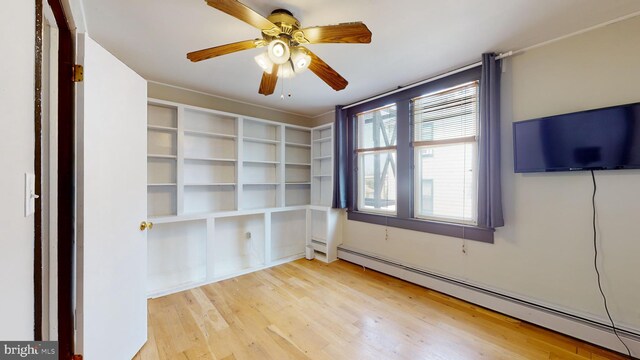 spare room featuring baseboard heating, light hardwood / wood-style floors, and ceiling fan